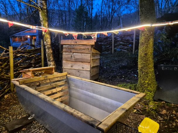 Photo showing the Swedish-style outdoor bath with lights and bunting